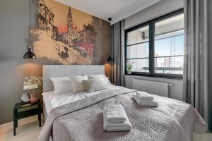 sypialnia z dużym łóżkiem i dużym oknem w obiekcie Flatbook - City Center Apartments Doki Living w Gdańsku