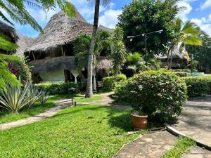 une maison au toit de chaume dans l'établissement Gemütliches Ferienhaus am weißen Sandstrand, à Malindi