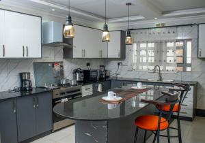 a kitchen with a large island with two bar stools at CACECY LUXURY HOMES in Bungoma