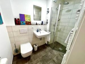 ein Bad mit einem WC, einem Waschbecken und einer Dusche in der Unterkunft Carefree Mikroapartment inkl. Balkon + Tiefgarage in Augsburg