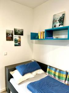 ein Schlafzimmer mit einem Bett und einem Regal mit Büchern in der Unterkunft Carefree Mikroapartment inkl. Balkon + Tiefgarage in Augsburg