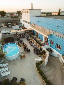 un groupe de personnes debout à l'extérieur d'un bâtiment avec piscine dans l'établissement Ostello Salento, à Alezio