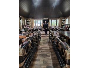 a man standing in the middle of a room with tables at Cherry Village Resort, Pelling, Sikkim in Pelling