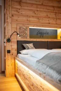 1 dormitorio con 1 cama con una señal encima en Zugspitze Apartment GLÜCK.AUF en Waldidylle