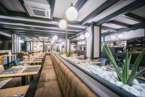 um restaurante com mesas e cadeiras e vasos de plantas em Kyriad Limoges Centre Gare - Atrium em Limoges