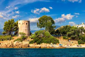ein Schloss am Ufer eines Wasserkörpers in der Unterkunft Le Corti Sarde On The Beach in Bari Sardo