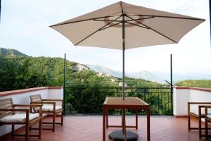 een tafel en stoelen met een parasol op een balkon bij Antica Rocca Dorotea - Salerno, Amalfi Coast in Salerno