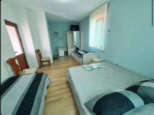 um quarto de hotel com duas camas e um sofá em House Varna-3 em Krapets