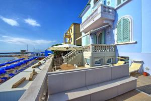 サン·ヴィンチェンツォにあるCasa Riva by PosarelliVillasの傘と椅子と海のある建物