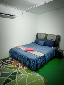 Bandar  Pusat JengkaにあるHomestay Bakti @Rantau Perintisのベッドルーム1室(床に青いカバーのベッド1台付)