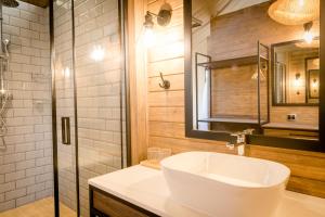 a bathroom with a white sink and a shower at Nkuhlu Tented Camp in Skukuza