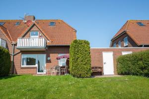 une maison avec une table et des chaises dans la cour dans l'établissement Up de Ring 26-28 Ferienwohnung 50175, à Carolinensiel