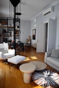 a living room with white furniture and a table at Thiseas Luxury Apartment in Athens