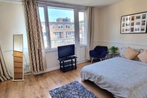 a bedroom with a bed and a large window at Large Duplex in Bermondsey in London