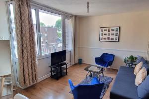 sala de estar con sofá, TV y ventana en Large Duplex in Bermondsey, en Londres