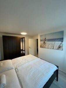 a bedroom with a large bed with a painting on the wall at xiApartment in Höchst