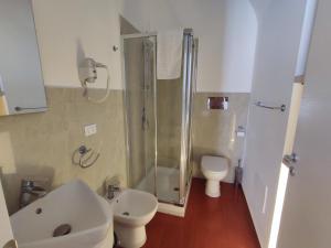 a bathroom with a shower and a toilet and a sink at Yhomisus in Comiso