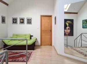 ein Wohnzimmer mit einem Bett und einer Tür in der Unterkunft Grange Des Arts in Saint-Nabor