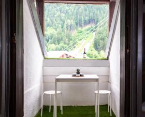 a table and two stools in front of a window at Duplex stylé face à l'Aiguille du Midi in Chamonix-Mont-Blanc