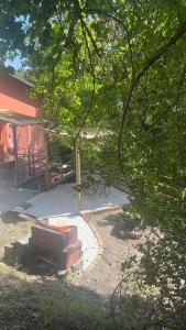 un patio trasero con un banco, una mesa y árboles en Lo scoiattolo bianco, en Massa