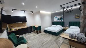 都拉斯Guest House Tian & Hojz的有两张床、一张桌子和几把椅子的房间