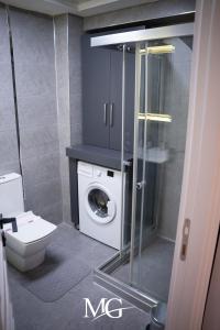 a bathroom with a toilet and a washing machine at MG HİLL RESİDENCE BUTİK OTEL in Yeşilyurt
