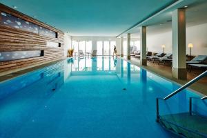 a swimming pool with blue water in a building at Hotel Anklamer Hof, BW Signature Collection in Anklam