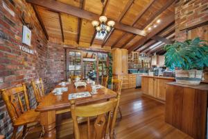 a dining room with a wooden table and a brick wall at Sea view holiday plant house , close to CBD and Beach in Kingston Beach