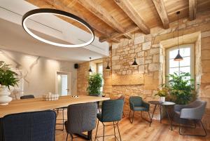 une salle à manger avec une grande table et des chaises en bois dans l'établissement hideauts hotels Le Chevalier bleu, à Monpazier