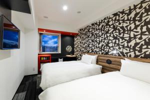 2 Betten in einem Hotelzimmer mit Wandbild in der Unterkunft the b asakusa in Tokio