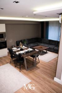 ein Wohnzimmer mit einem Tisch und einem Sofa in der Unterkunft MG HİLL RESİDENCE BUTİK OTEL in Yeşilyurt