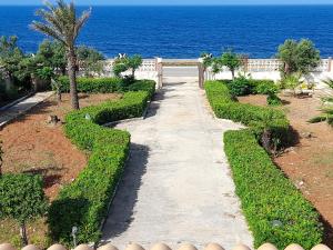 a walkway leading to a garden with the ocean at Casa Vacanze Villa Enza in Mazara del Vallo