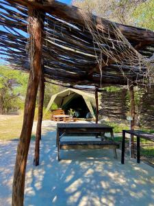 ein Zelt mit einem Picknicktisch davor in der Unterkunft Kuvira River Camp in Divundu