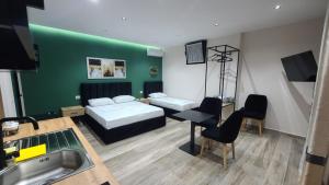 a bedroom with a bed and a desk and a sink at Guest House Tian in Durrës