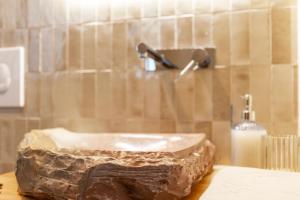 een stenen wastafel in een badkamer met een douche bij Toni Retzo Rooms in Himare