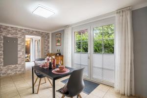 uma sala de jantar com mesa, cadeiras e janelas em Ferienwohnung For two em Mahlberg