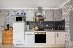 a kitchen with white cabinets and a stove top oven at Ferienwohnung For two in Mahlberg