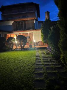 a house with a pathway leading to a yard at night at Zasheva Kushta Guesthouse in Bansko