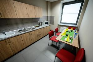 a small kitchen with a table and red chairs at HOSTEL PARKOWY in Morawica +10 photos