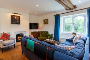 a living room with blue couches and a fireplace at Lower Lodge Gatehouse at Kentchurch 