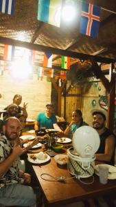 un grupo de hombres sentados en una mesa comiendo comida en Good Vibes Bungalows en Gili Trawangan