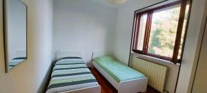 una piccola camera con due posti a sedere in una stanza con finestra di Casa in montagna con giardino privato recintato ad Andrate