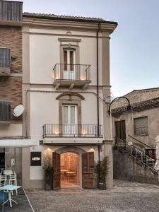 um grande edifício branco com uma varanda e um pátio em B&B Palazzo Bruni - Dimora di Mare em Marina di San Vito