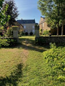 um quintal com uma casa ao fundo em Le Poulailler em Loué
