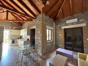 a kitchen and living room with a table and chairs at To Petrino Condo in Stoupa