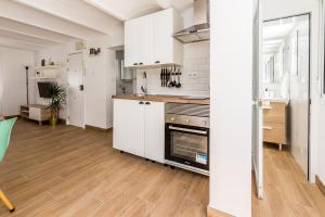 kuchnia z białymi szafkami i kuchenką w obiekcie Apartamento en CENTRO CIUDAD w mieście El Puerto de Santa María