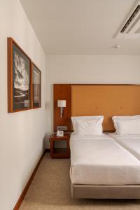 a hotel room with two beds and a table at Hotel Dom Carlos Liberty in Lisbon