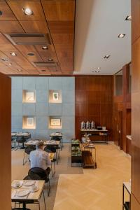 a man sitting at tables in a dining room at Hotel Dom Carlos Liberty in Lisbon