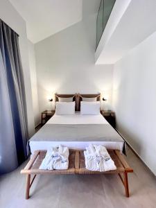 1 dormitorio con 1 cama y toallas en una mesa en La Mer Luxury Apartments en Ierissos