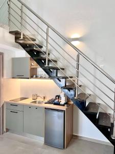 a kitchen with a spiral staircase in a house at La Mer Luxury Apartments in Ierissos